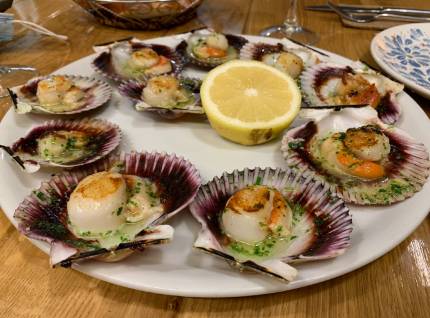 Plato con decena de zamburiñas a la plancha con rodaja de limón del Kaloka